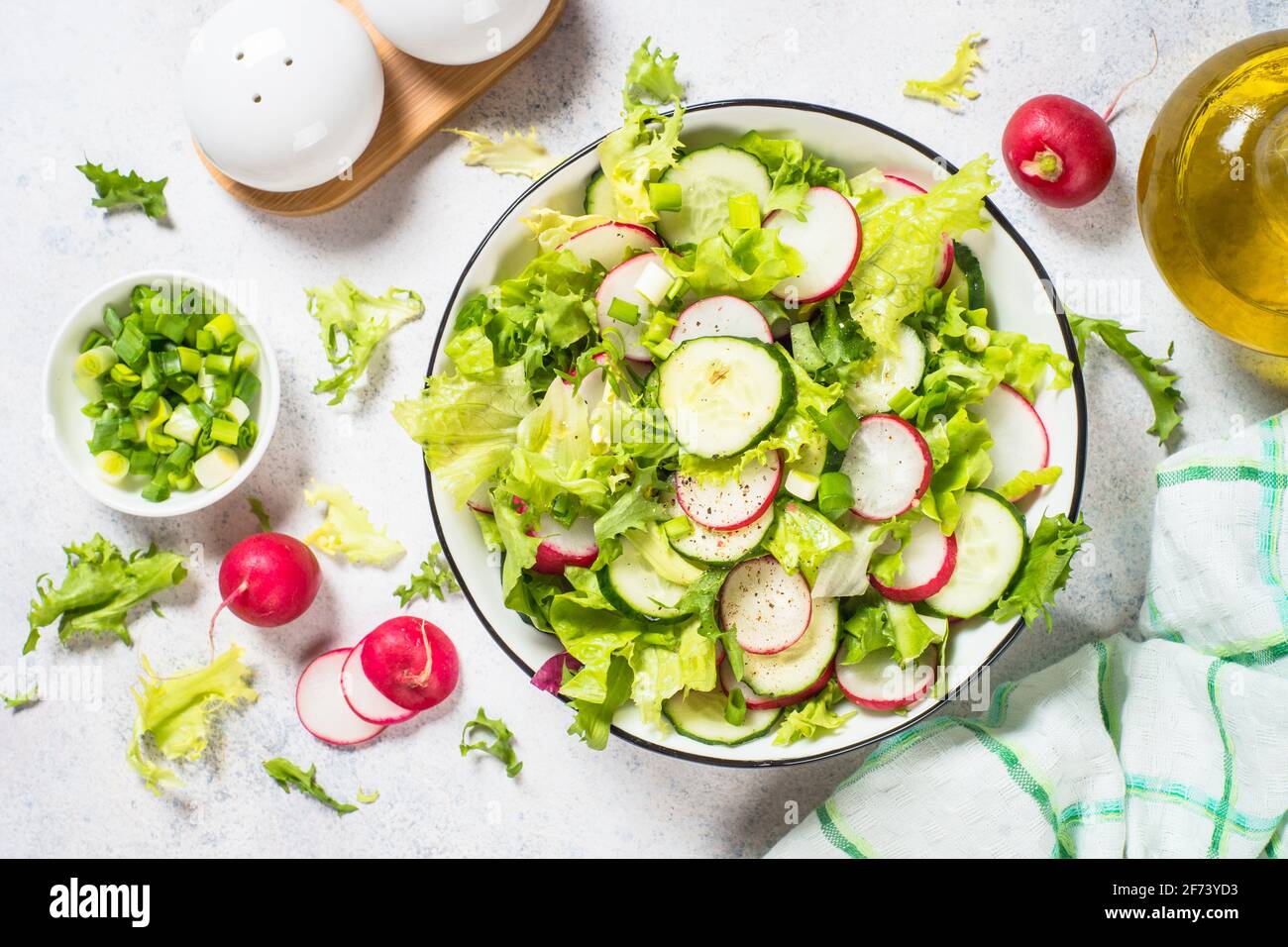 Grüner Salat mit frischen Blättern, Rettich, Gurke und ollivem Öl. Stockfoto