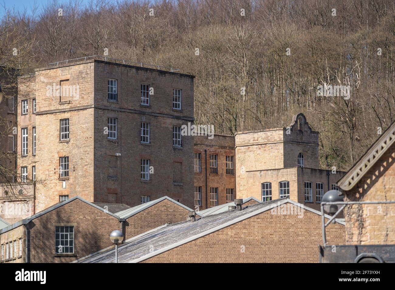 Verlassene alte 1800 industrielle Revolution Baumwollmühle außen. Hohe viktorianische Steingebäude mit Fenstern. Stockfoto