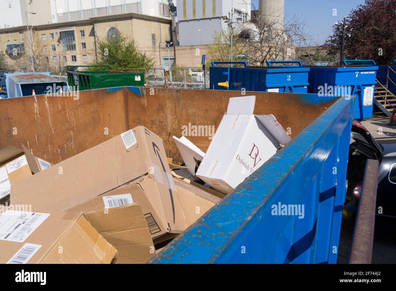 Karton wurde im Recycling-Zentrum, New Cross London, Großbritannien, in einen Recyclingbehälter geworfen Stockfoto