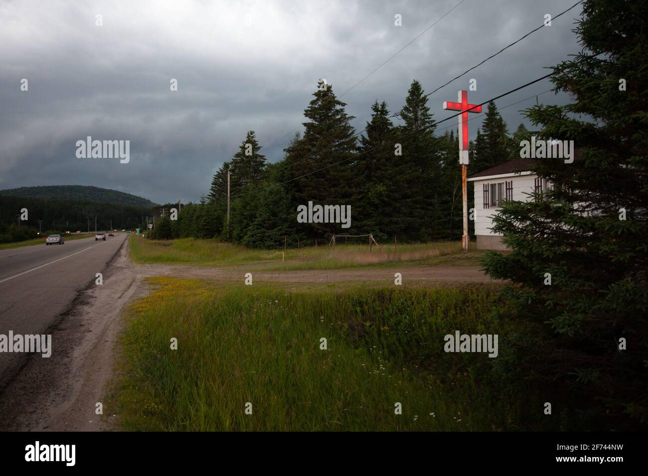 Rotes Kreuz an einem regnerischen Tag an der Grenze einer Straße in einer abgelegenen Landschaft in Quebec, Kanada Stockfoto