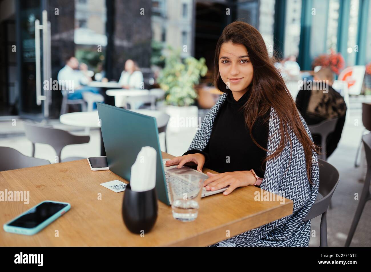 Portrait einer Studentin, die im Café mit einem Netzbuch sitzt Stockfoto