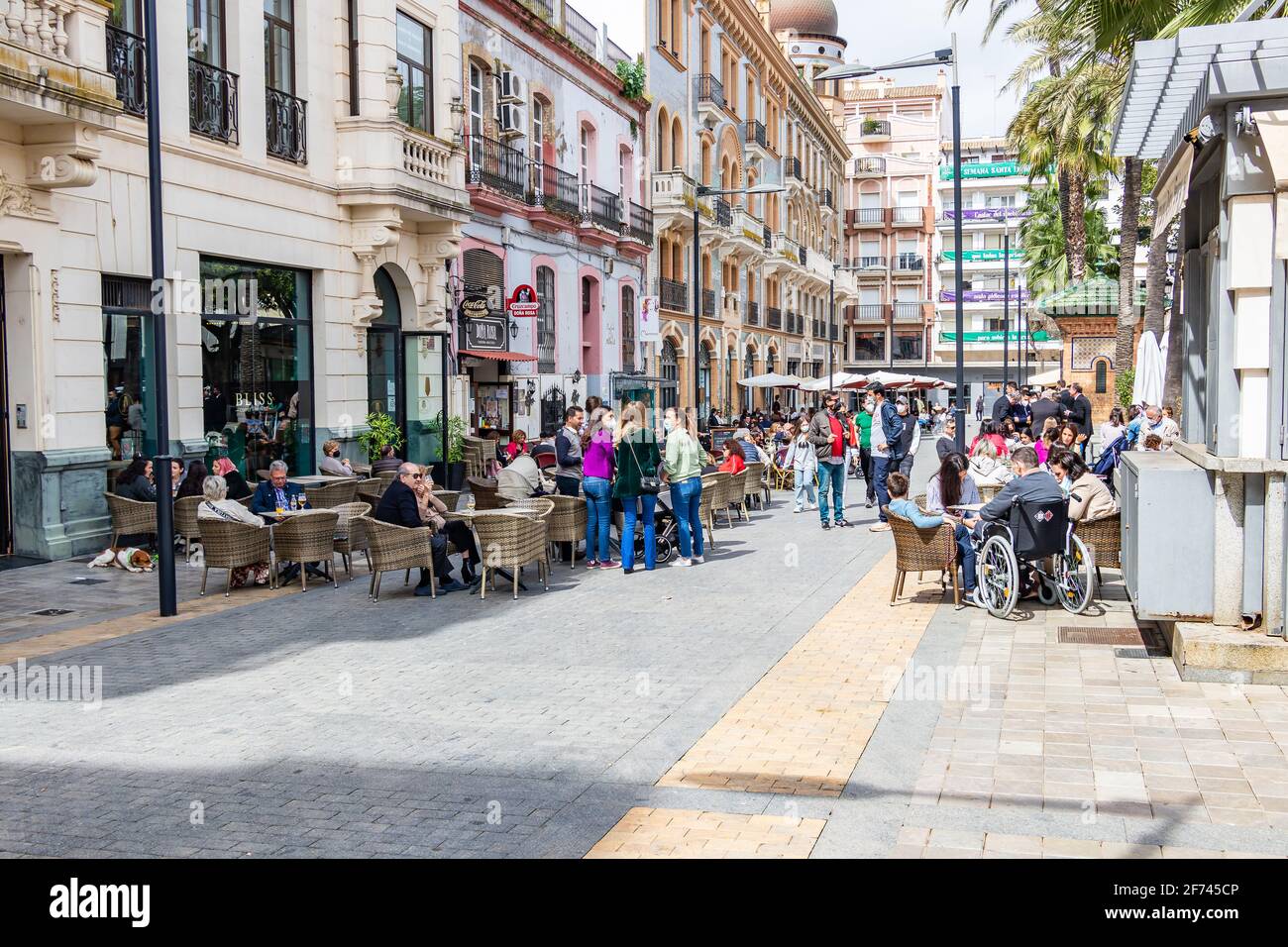 Huelva, Spanien - 1. April 2021: Menschen, die auf der Terrasse eines Cafés und einer Bar auf dem Platz Plaza de las Monjas (Nonnen-Platz) von Huelva sitzen, tragen ein p Stockfoto