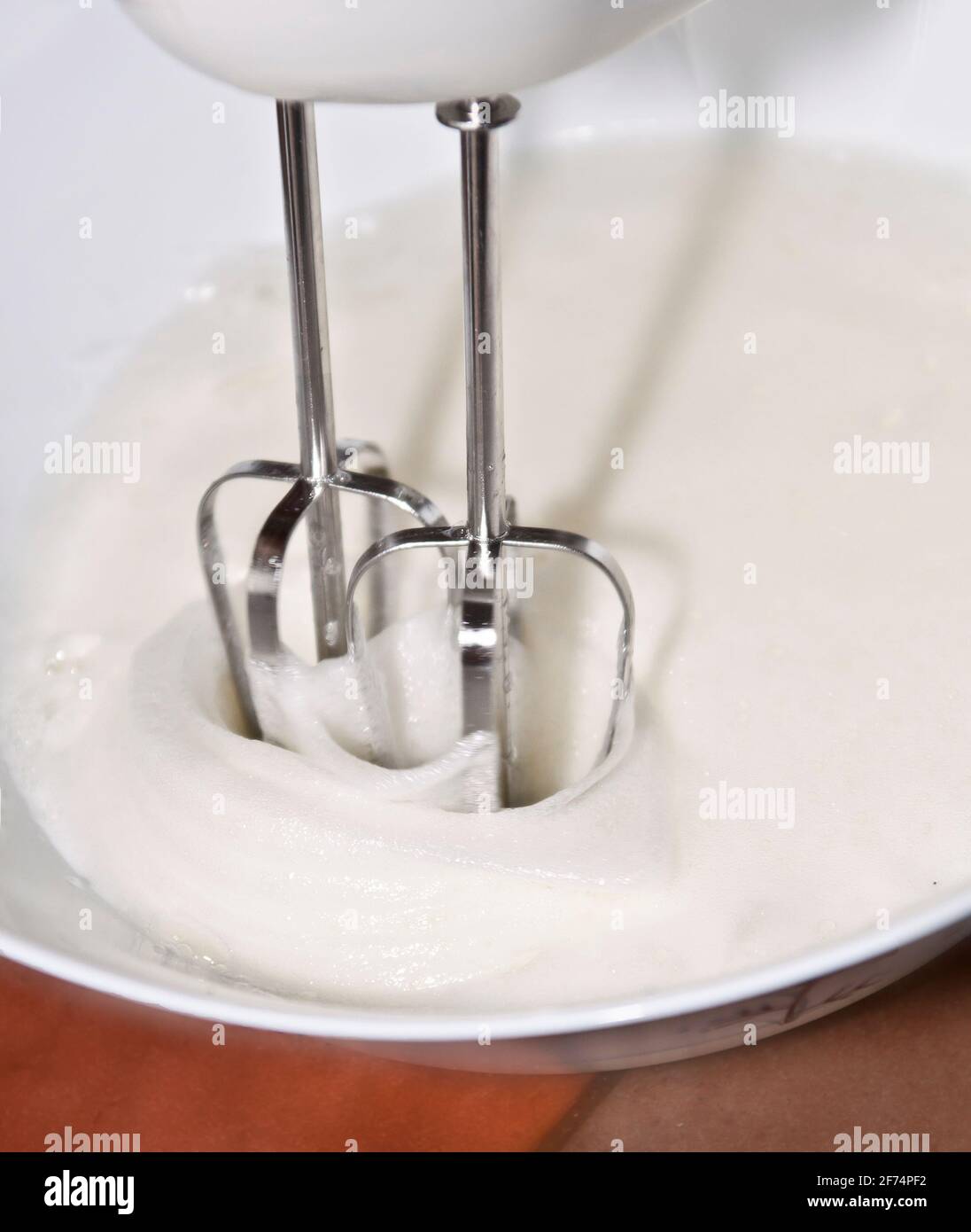 Kuchen machen: Foto, das die Bewegung eines elektrischen Schneebeckens fängt, der zum Mischen von Eiern verwendet wird. Stockfoto