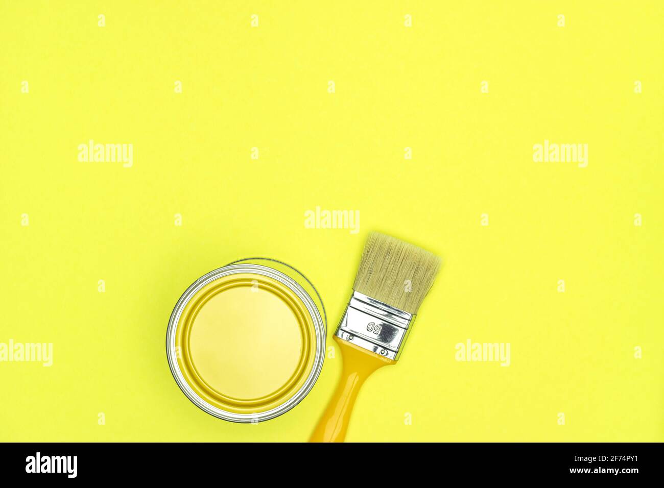 Gelbe Farbe kann mit Pinsel auf leuchtenden gelben Hintergrund. Draufsicht, kopieren Raum Stockfoto