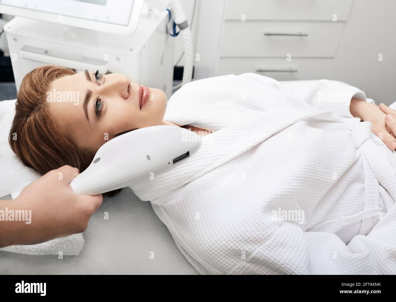 Kosmetikerin entfernt braune Flecken auf der Haut einer Frau im Schönheitssalon. Hautverjüngung einer schönen Frau Stockfoto