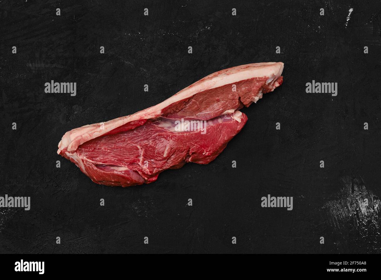 Blick von oben auf rohes Rindfleisch Ribeye Lippe auf mit Haut Auf schwarzem Hintergrund Stockfoto