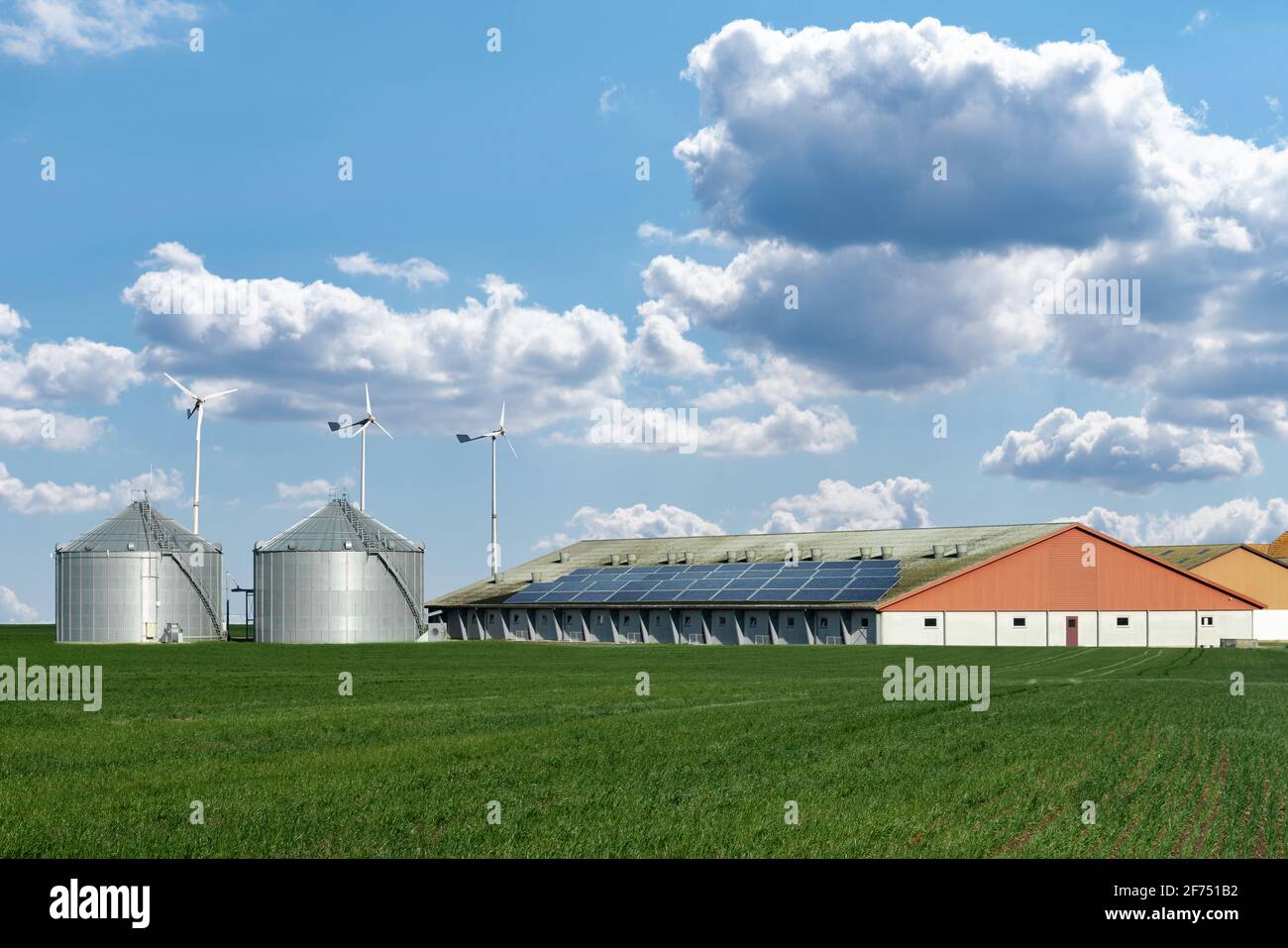 Moderner Milchviehbetrieb mit erneuerbarer Energie, Solarzellen und Windkraftanlagen Stockfoto