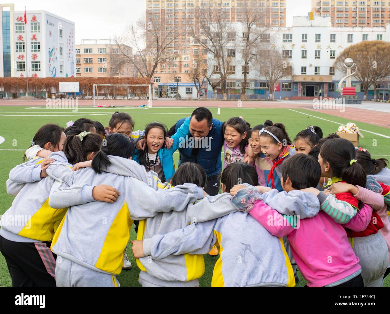 (210405) -- SHAWAN, 5. April 2021 (Xinhua) -- Xia Songhao (C) feuert seine Schüler vor einer Trainingseinheit in der Stadt Shawan, im Nordwesten Chinas, der Autonomen Region Xinjiang Uygur, am 31. März 2021 an. 2011 wurde die Mädchen-Fußballmannschaft der Grundschule Nr. 2 in Shawan City gegründet. Unter der Leitung von Xia Songhao, der seit fast zehn Jahren Fußball auf dem Campus trainiert, hat sich die Fußballmannschaft der Mädchen zu einer vielfältigen Gruppe aus multiethnischen Spielern entwickelt. Nach kontinuierlichem und strengem Training hat das Team hervorragende Ergebnisse erzielt und eine Reihe von Meisterschaften auf verschiedenen Ebenen gewonnen. (X Stockfoto