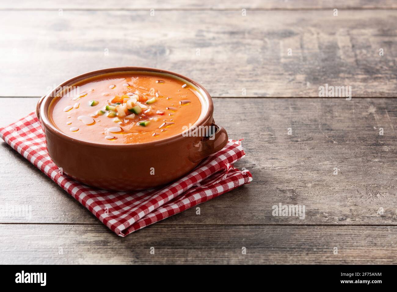 Gazpachosuppe in einem Kropf auf einem Holztisch Stockfoto