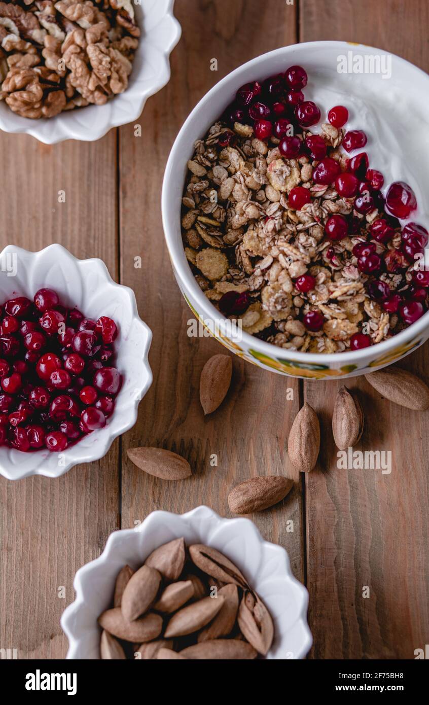 Gesunde Snacks. Vielfalt an Superfood: Nüsse, Beeren, Körner auf Holzgrund. Draufsicht Stockfoto