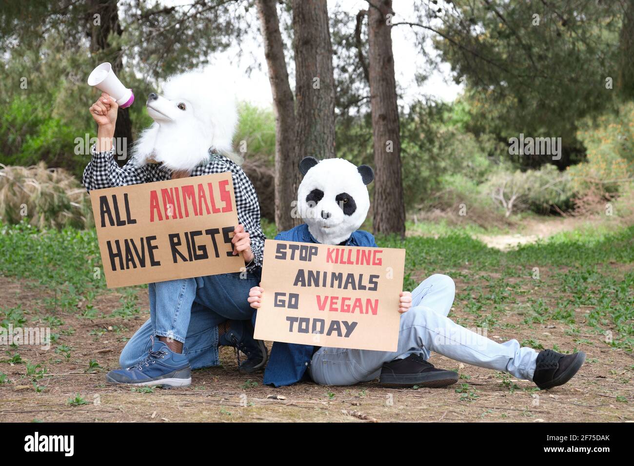 Aktivistische Demonstranten, die Tiermasken tragen und durch ein Bullhorn rufen, um Grausamkeit hervorzuheben und den veganen Lebensstil zu fördern. Tierrechtsproteste in einem Vordergrund Stockfoto