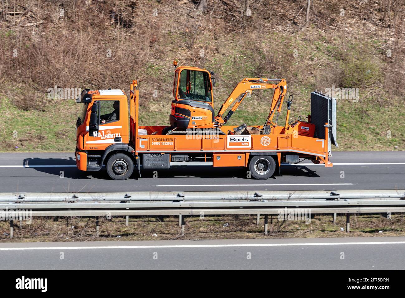 Boels Rental Iveco LKW mit Mini-Bagger auf der Autobahn beladen. Stockfoto