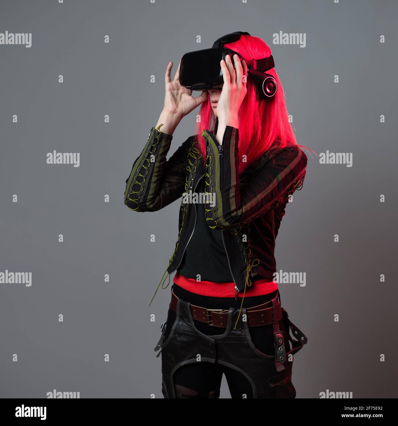 Stylischer junger Gamer in einem Virtual-Reality-Helm, spielt in Simulationen, moderner Technologie und der Gaming-Industrie. Stockfoto