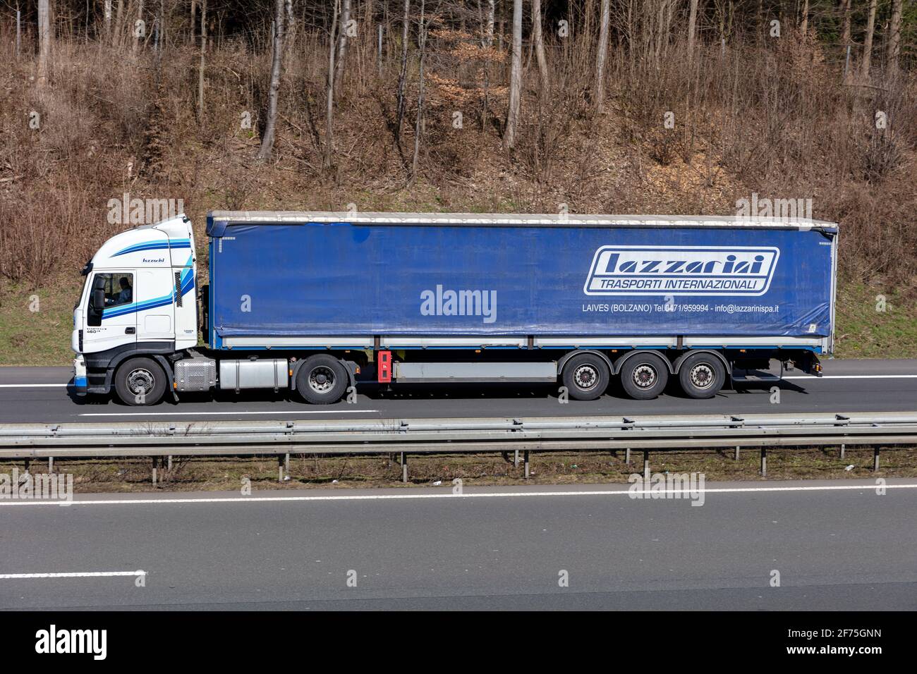 Lazzarini Iveco Stralis LKW mit Planenauflieger auf der Autobahn. Stockfoto