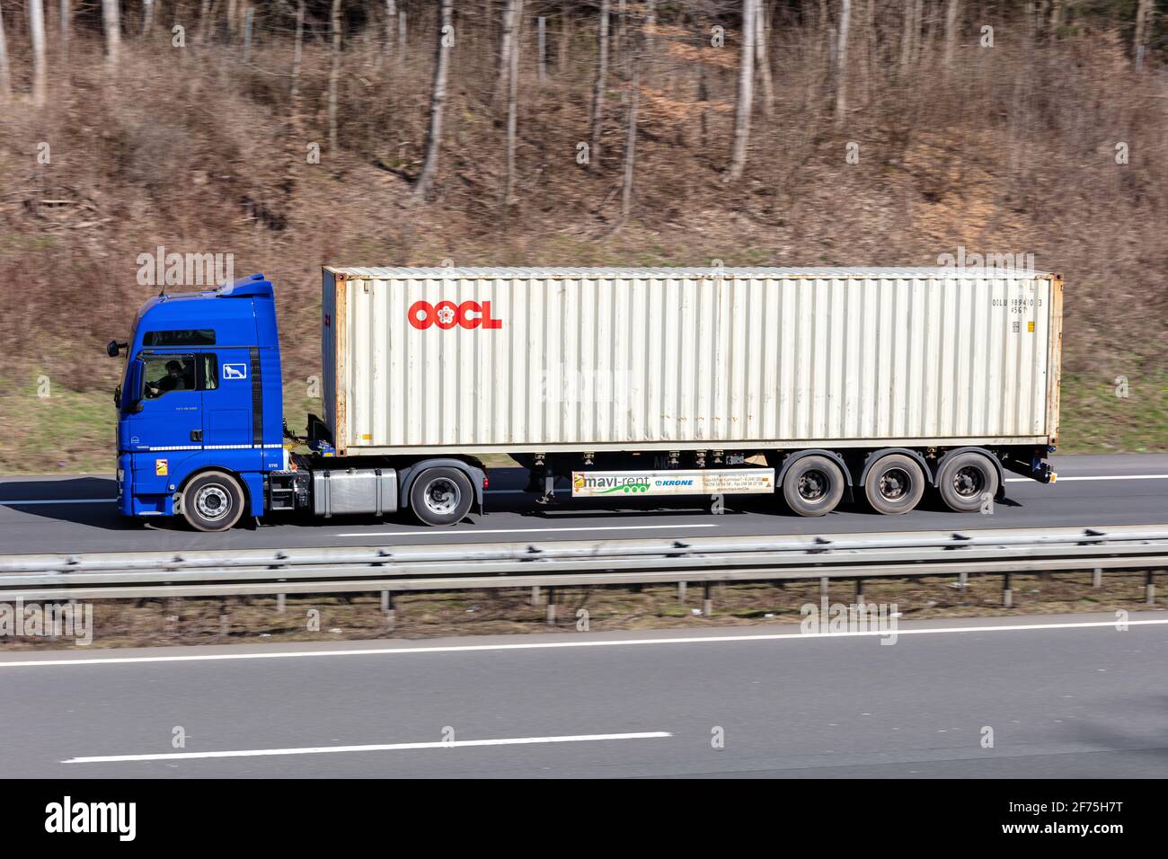 MAN TGX LKW mit OOCL Container auf Autobahn. Stockfoto