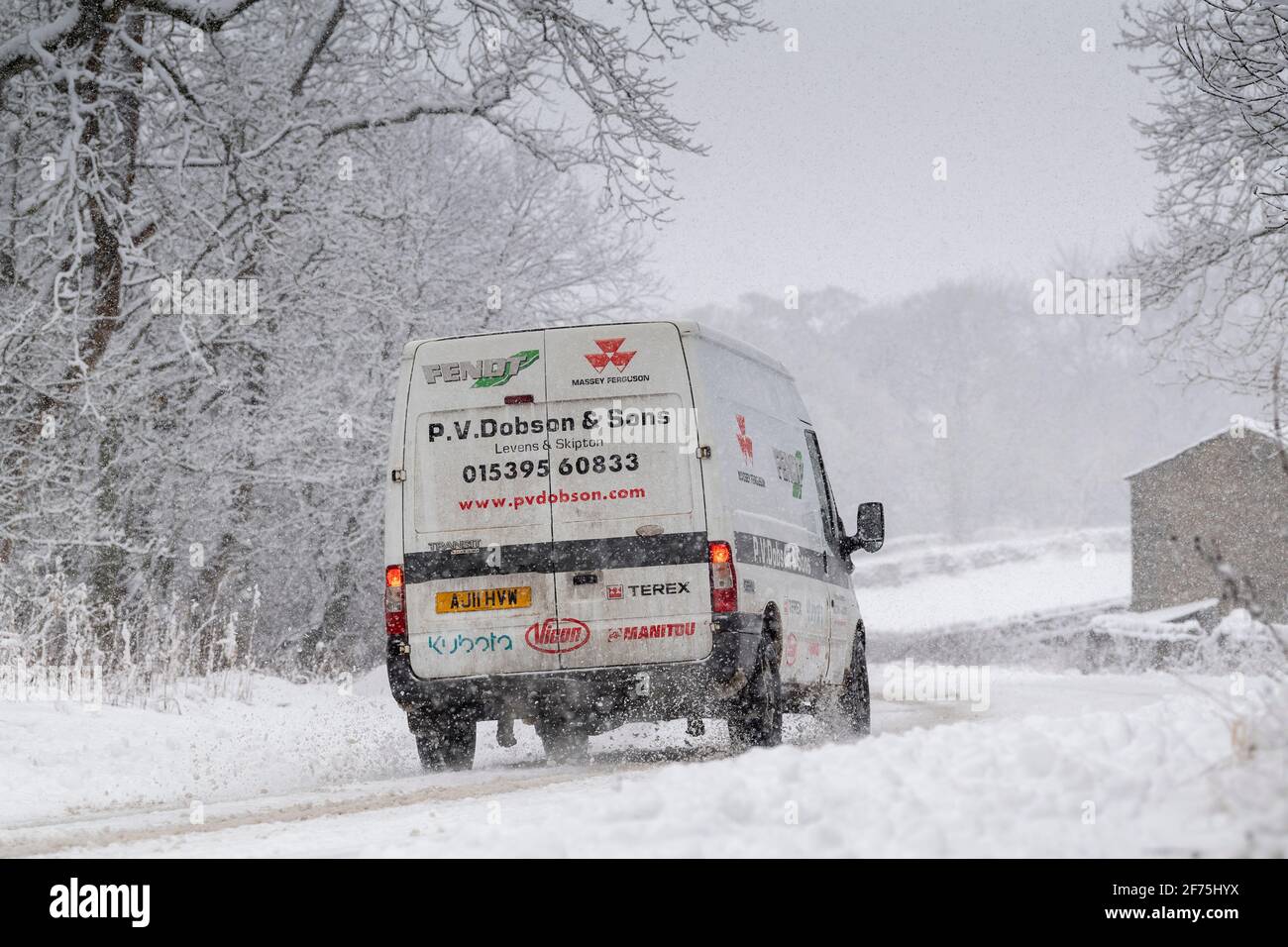 Van fährt eine schneebedeckte A684 Straße in der Nähe von Hawes in Wensleydale, North Yorkshire, Großbritannien. Stockfoto