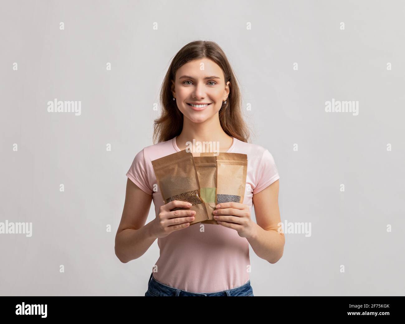 Eco Storage-Konzept. Lächelnde Millennial-Dame mit Doypack-Taschen und Gewichteinkäufen Stockfoto