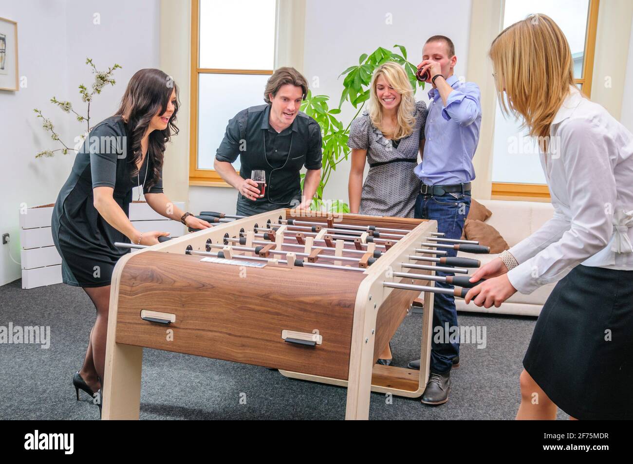 Menschen spielen Tischfußball auf einem hölzernen Kicker Stockfoto