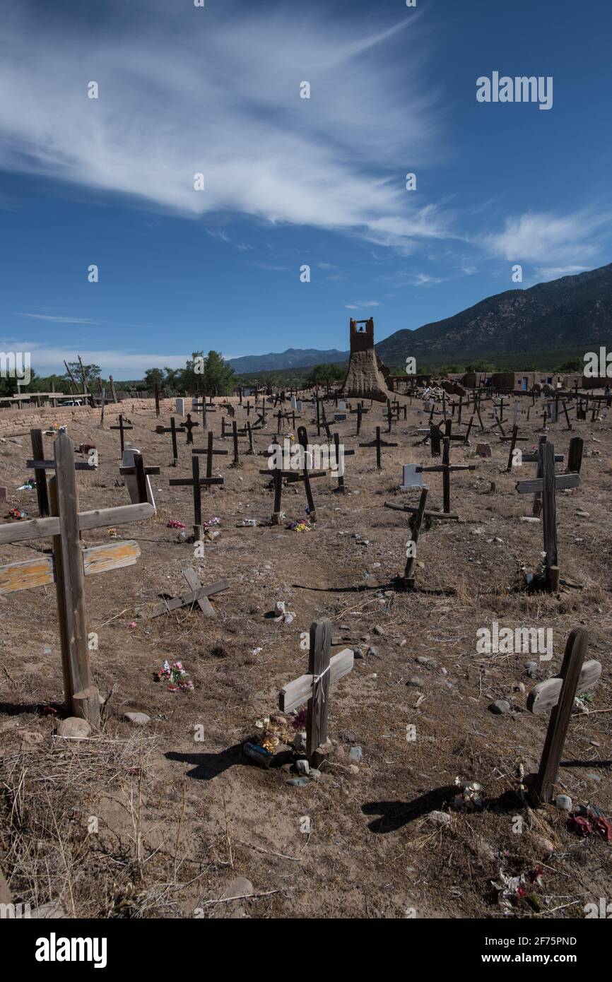 Der historische Taos Pueblo Friedhof in New Mexico mit verwitterten Holzkreuzen, die die Gräber der indianischen Gemeinde markieren. Stockfoto