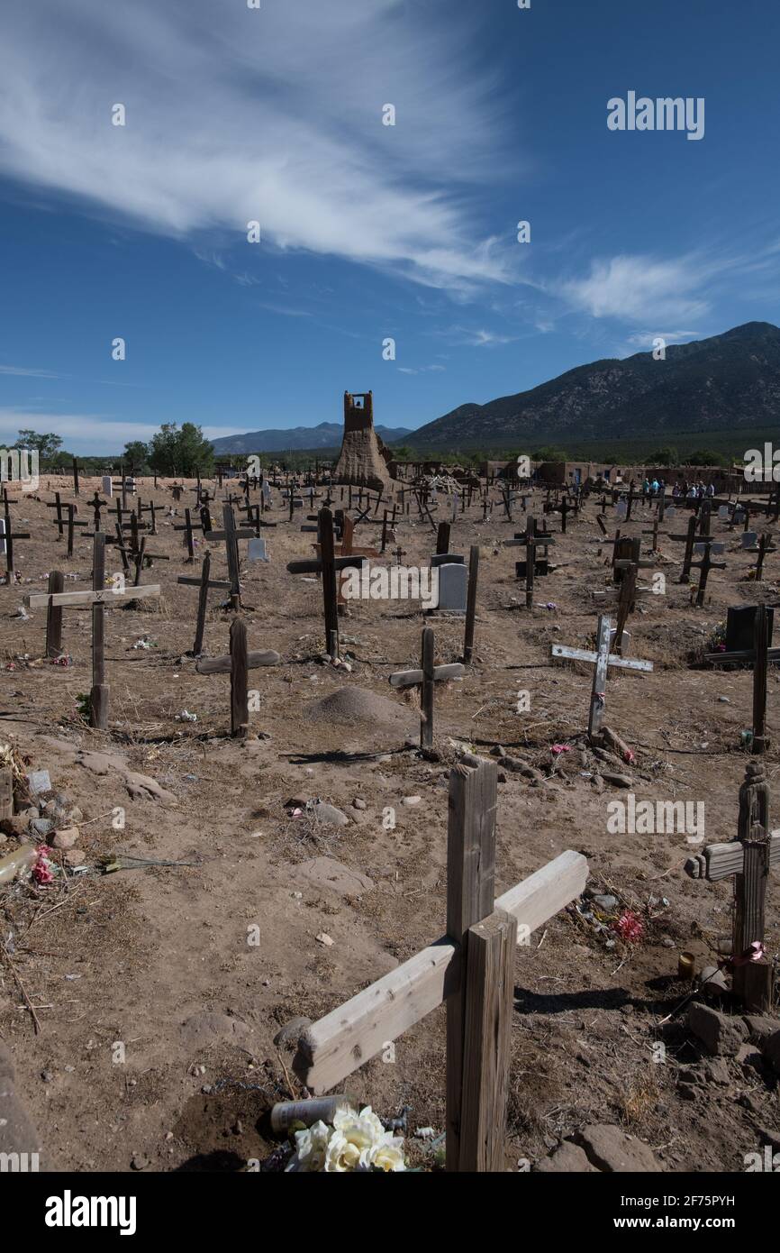 Der historische Taos Pueblo Friedhof in New Mexico mit verwitterten Holzkreuzen, die die Gräber der indianischen Gemeinde markieren. Stockfoto