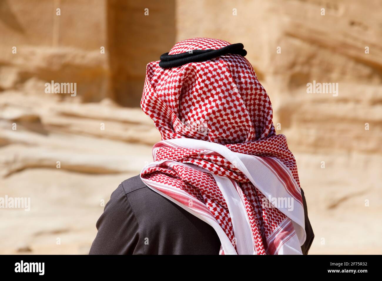 Al Ula, Saudi-Arabien, Februar 19 2020: Ein Saudi-arabischer Tourist mit traditionellem Kopfschmuck steht vor einem Grab in Al Ula Stockfoto