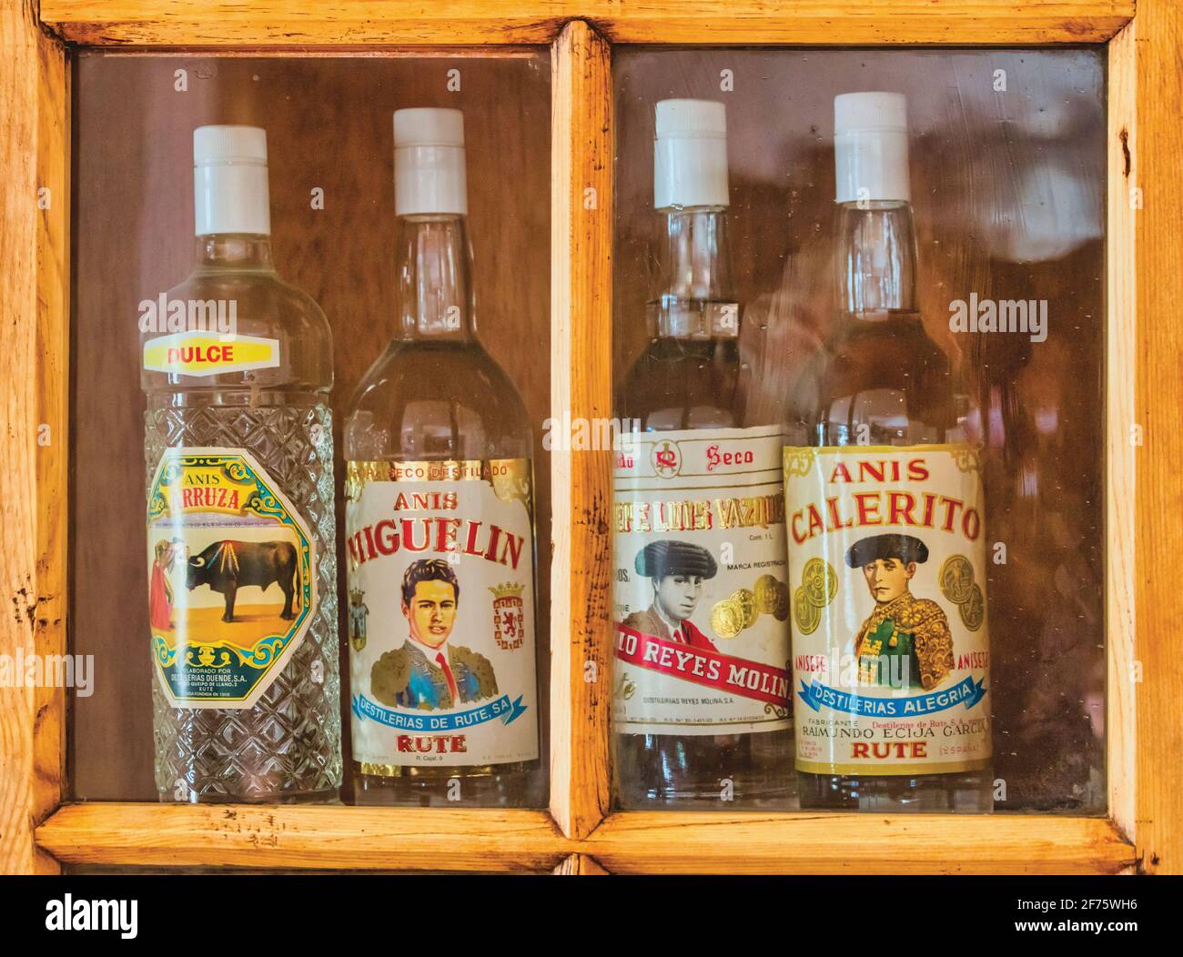 Vier Flaschen Aniseis im Schaufenster, die den Stierkampf mit Bildern von Stierkämpfer feiern. Ronda, Provinz Malaga, Andalusien, Spanien. In Spanien Ani Stockfoto