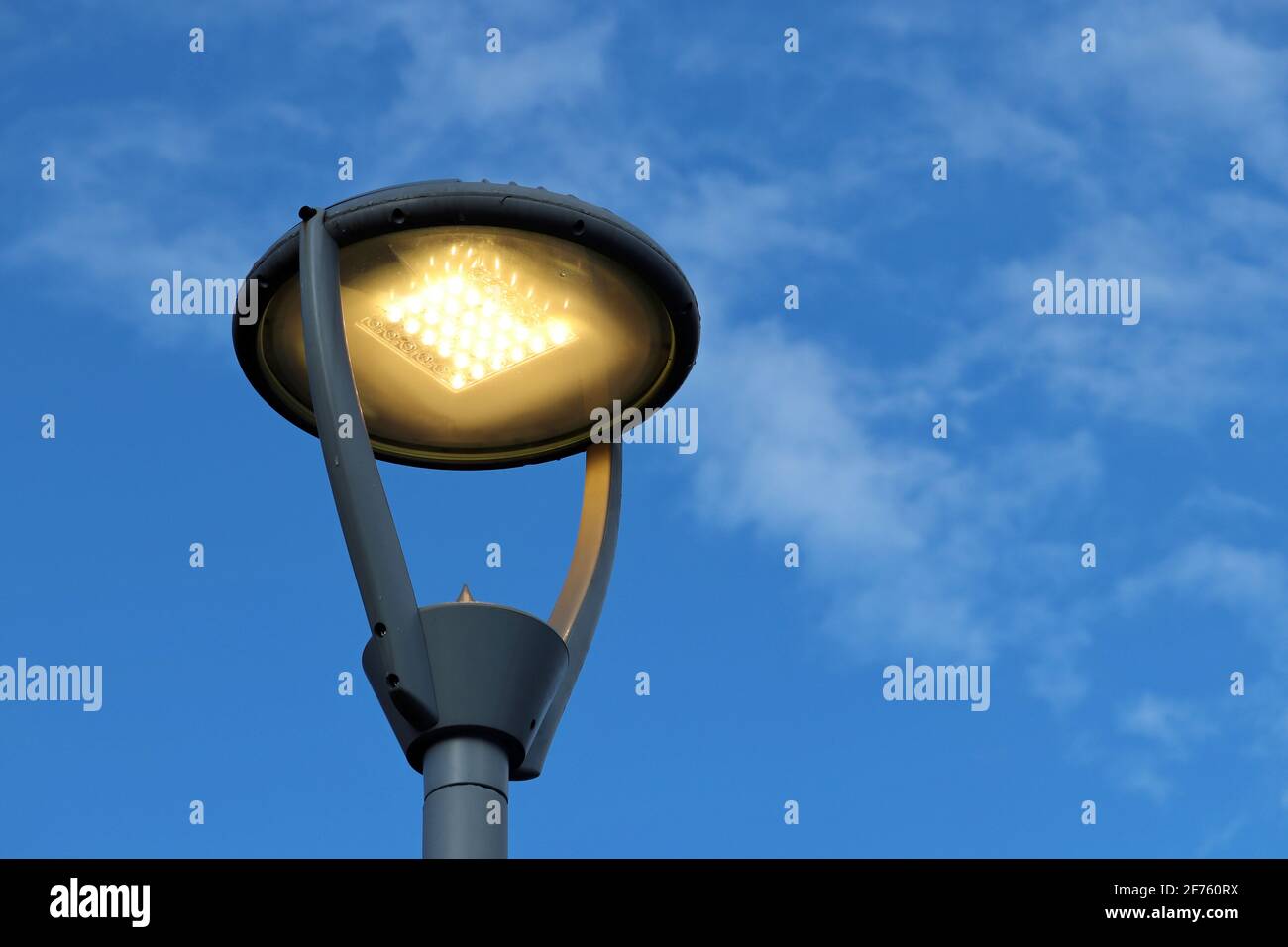 LED-Lampe leuchtet auf blauem Himmel und weißen Wolken Hintergrund.  Elektrische Beleuchtung, energiesparende Straßenlaterne Stockfotografie -  Alamy