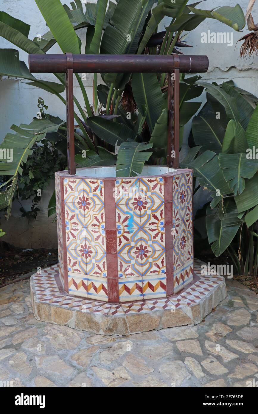 Ein farbenfrohes Keramikkunstwerk eines Wasserbrunnen in einer grünen Ecke in Estepona in Spanien Stockfoto