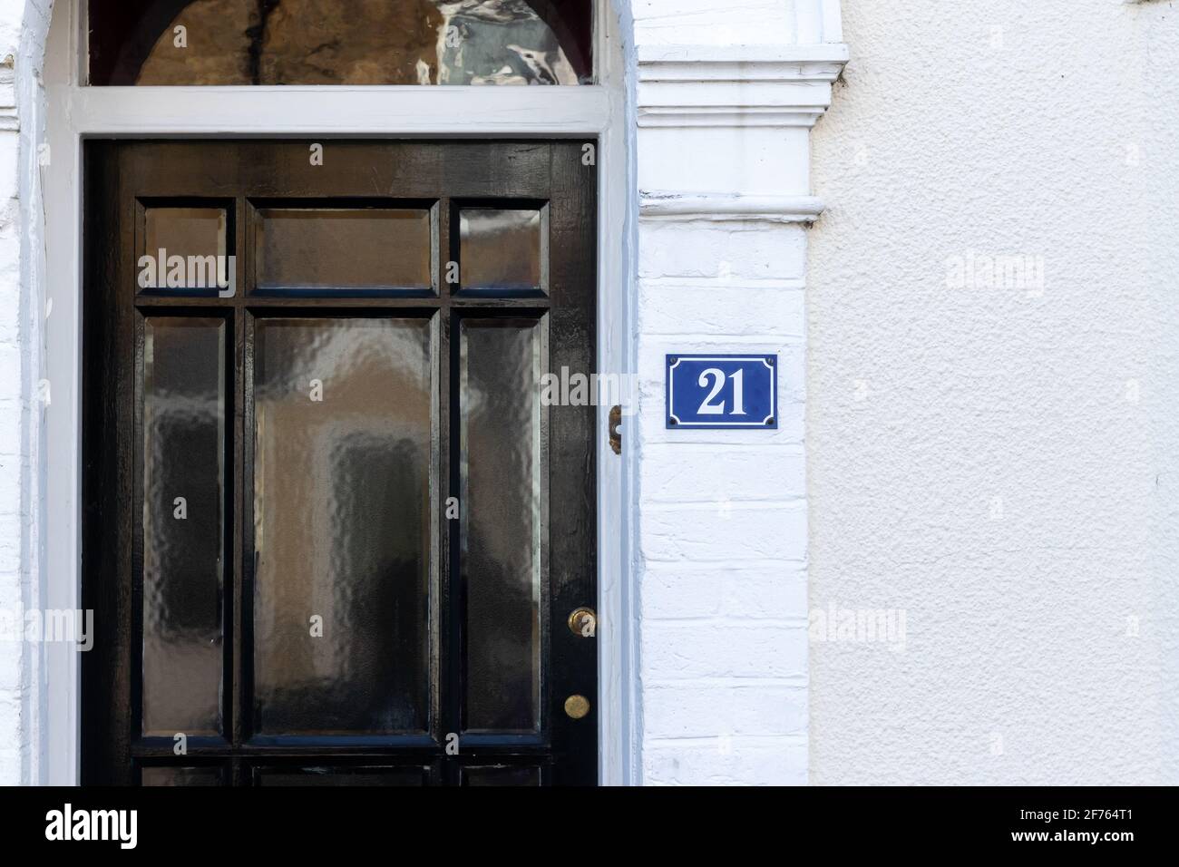 Hausnummer 21neben einer eingelassenen Türe mit Black Stockfoto