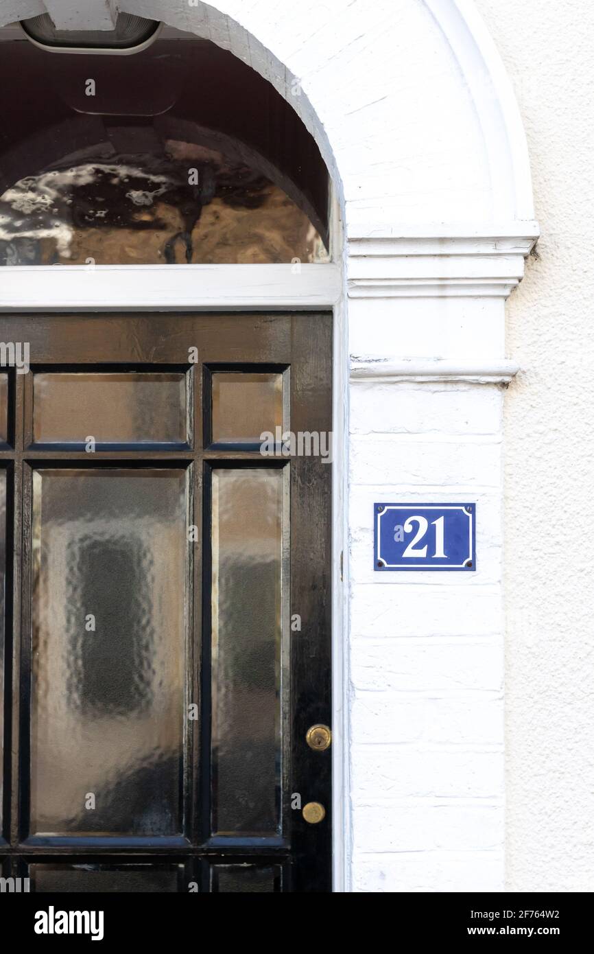Haus Nummer 21 neben einer eingelassenen Türe Stockfoto