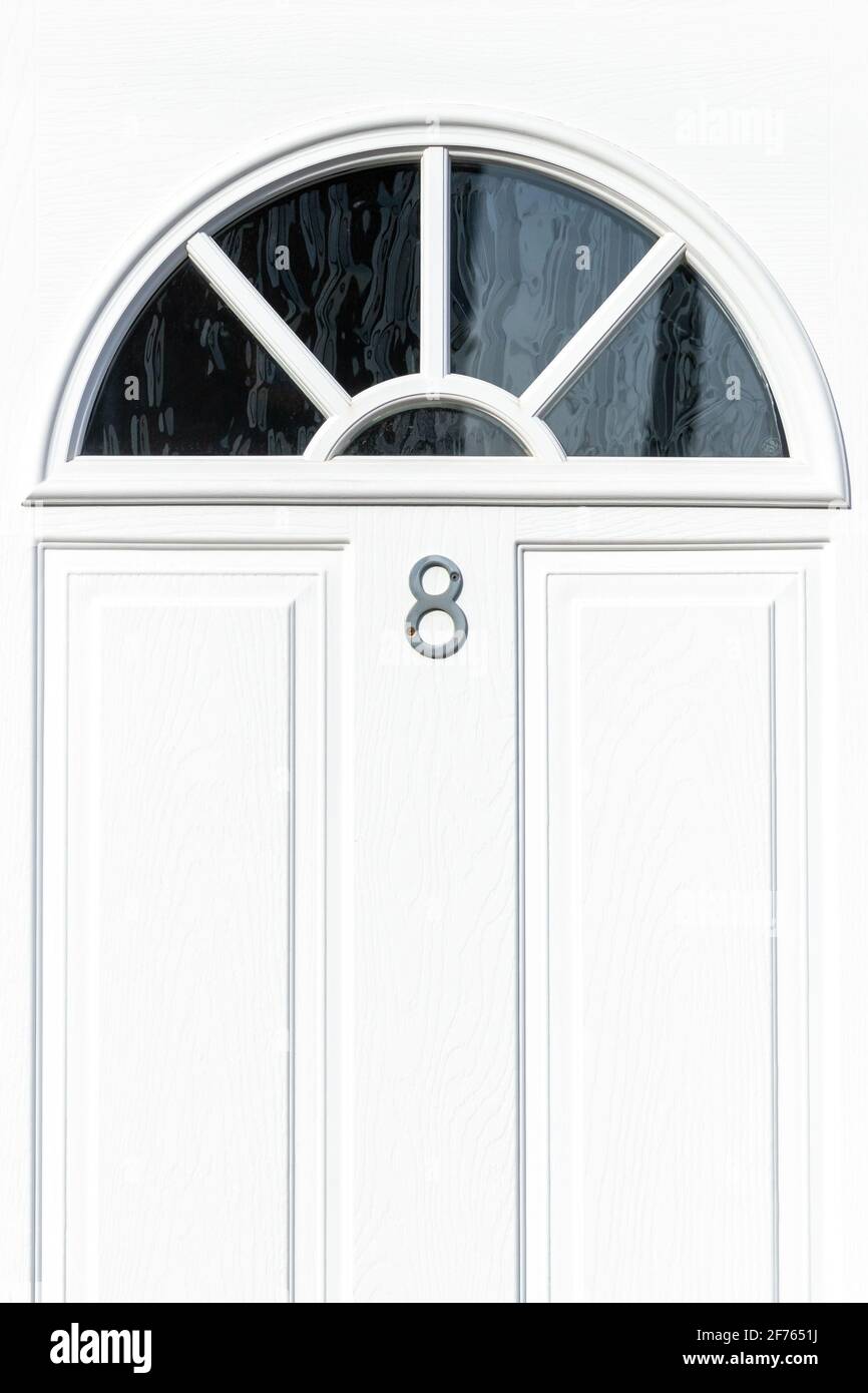 Hous numbr 8 an einer weißen Holztür Stockfoto