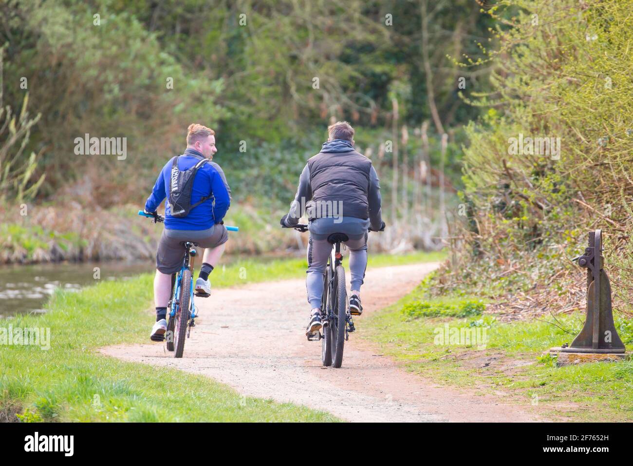 Kidderminster, Großbritannien. April 2021. Wetter in Großbritannien: Zwei Freunde radeln auf einem Abflutweg des Worcestershire-Kanals an einem hellen, aber ziemlich kühlen Osterfeiertag. Kredit: Lee Hudson/Alamy Live Nachrichten Stockfoto