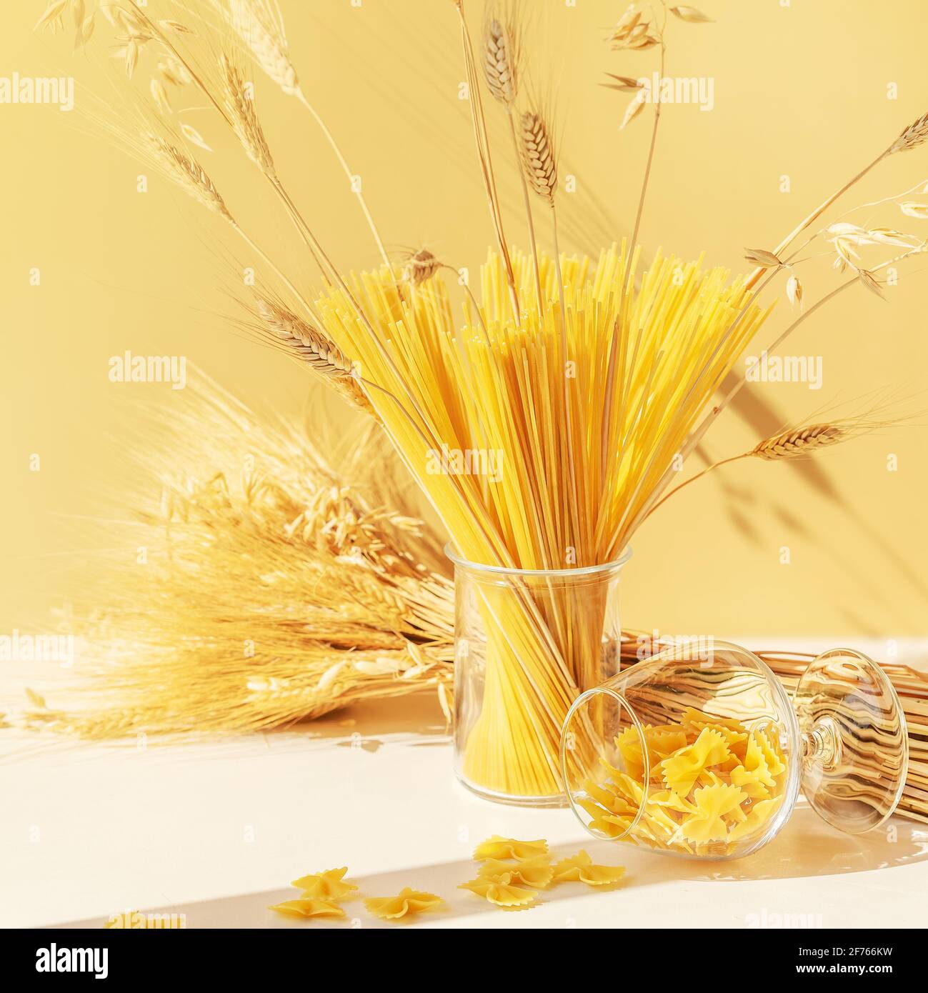 Lebensmittelzusammensetzung aus rohen Spaghetti, Farfalle-Pasta in Gläsern mit einem Weizenstrauß auf hellem Hintergrund. Zero Waste Konzept, kein Kunststoff. Öko-Frie Stockfoto