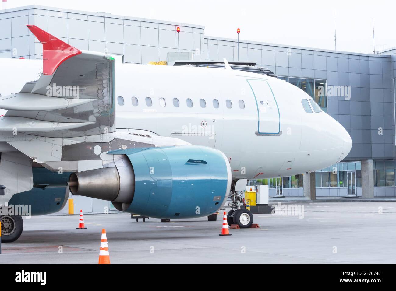 Geparktes Flugzeug in einer Bordbrücke vor dem Flughafenterminal Gebäude Stockfoto