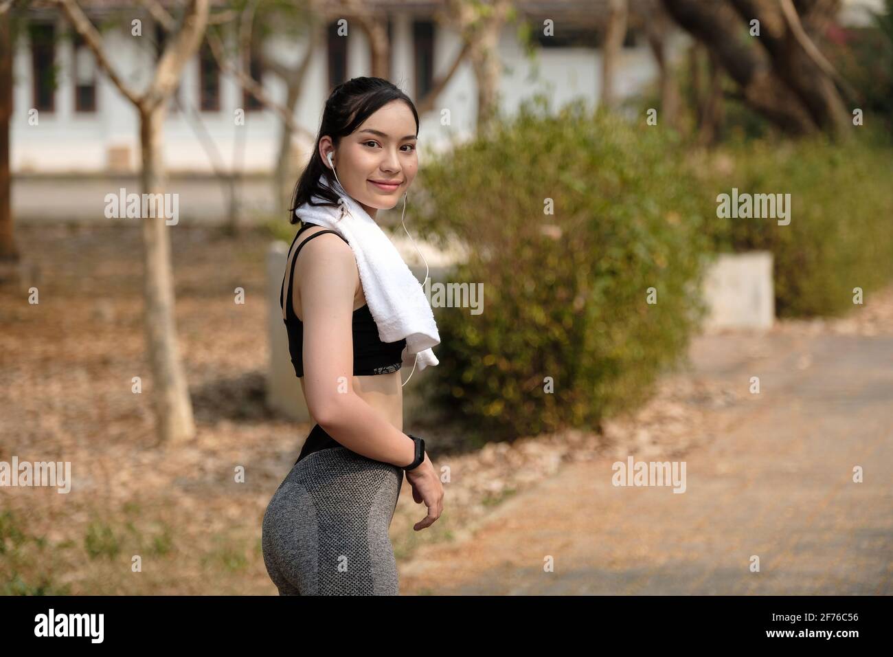 Glückliches Porträt eines sportlichen Mädchens, das in der Kamera lächelt Der Garten Stockfoto