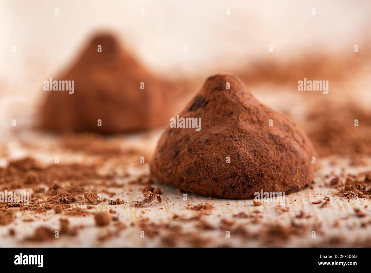 Schokoladentrüffel auf Holzbrett mit Kakaopulver herstellen - Nahaufnahme Stockfoto