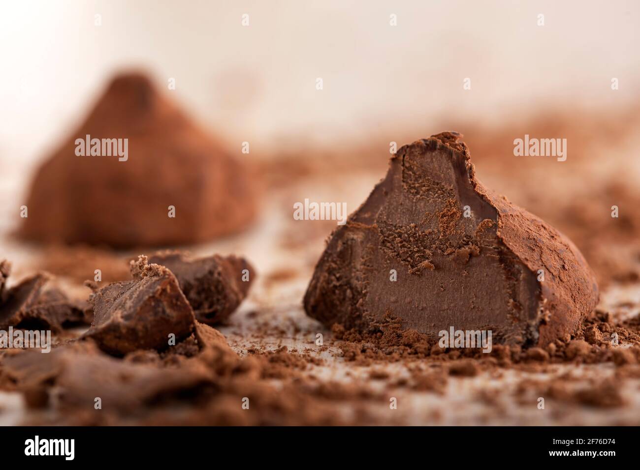 Nahaufnahme eines handgefertigten Schokoladentrüffels auf einem Holzbrett Mit Kakaopulver - Nahaufnahme Stockfoto