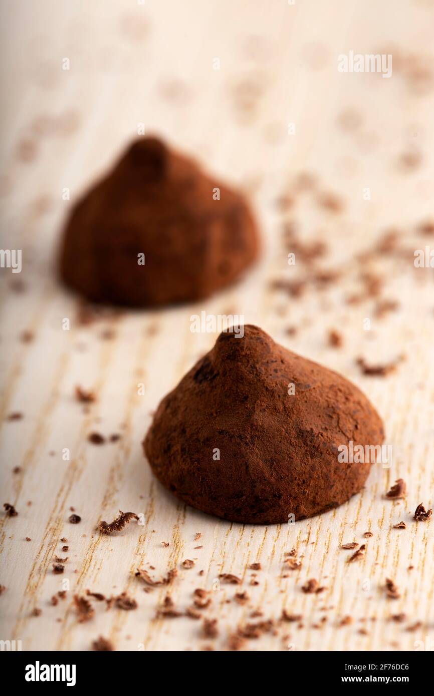 Basteln Sie Schokoladentrüffel auf Holzbrett mit Kakaopulver Stockfoto