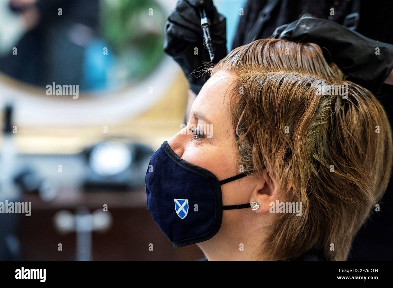 Schottlands erste Ministerin Nicola Sturgeon trägt eine Gesichtsbedeckung, da sie ihre Haare im Beehive Hair von Julie McGuire gefärbt und geschnitten hat und während der Wahlkampagne für die schottischen Parlamentswahlen in Edinburgh Friseursalon macht. Bilddatum: Montag, 5. April 2021. Stockfoto
