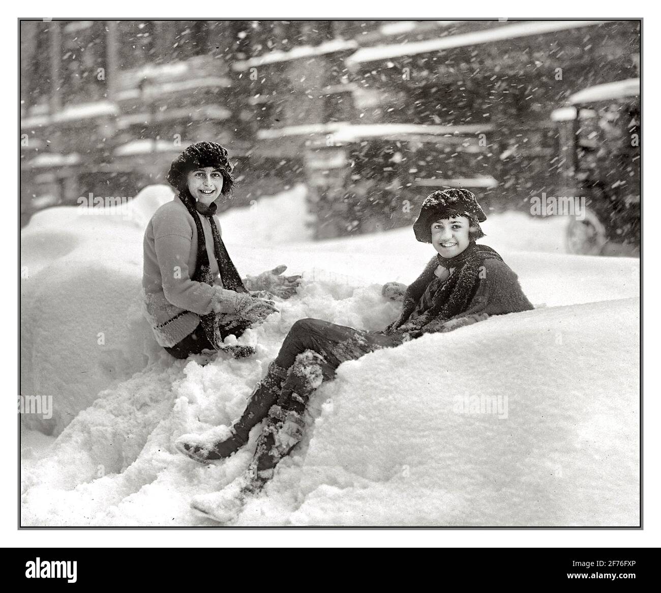 WASHINGTON USA SNOW SNEWING WINTER FUN GIRLS Archive Heavy Snow Blizzard, 28. Januar 1922. In Washington, D.C., ist eiskaltes Wetter nicht geeignet für eine sonnige Stimmung. Zwei Mädchen über die Stadt, die das Beste aus einem harten Winter in Washington DC USA machen Stockfoto