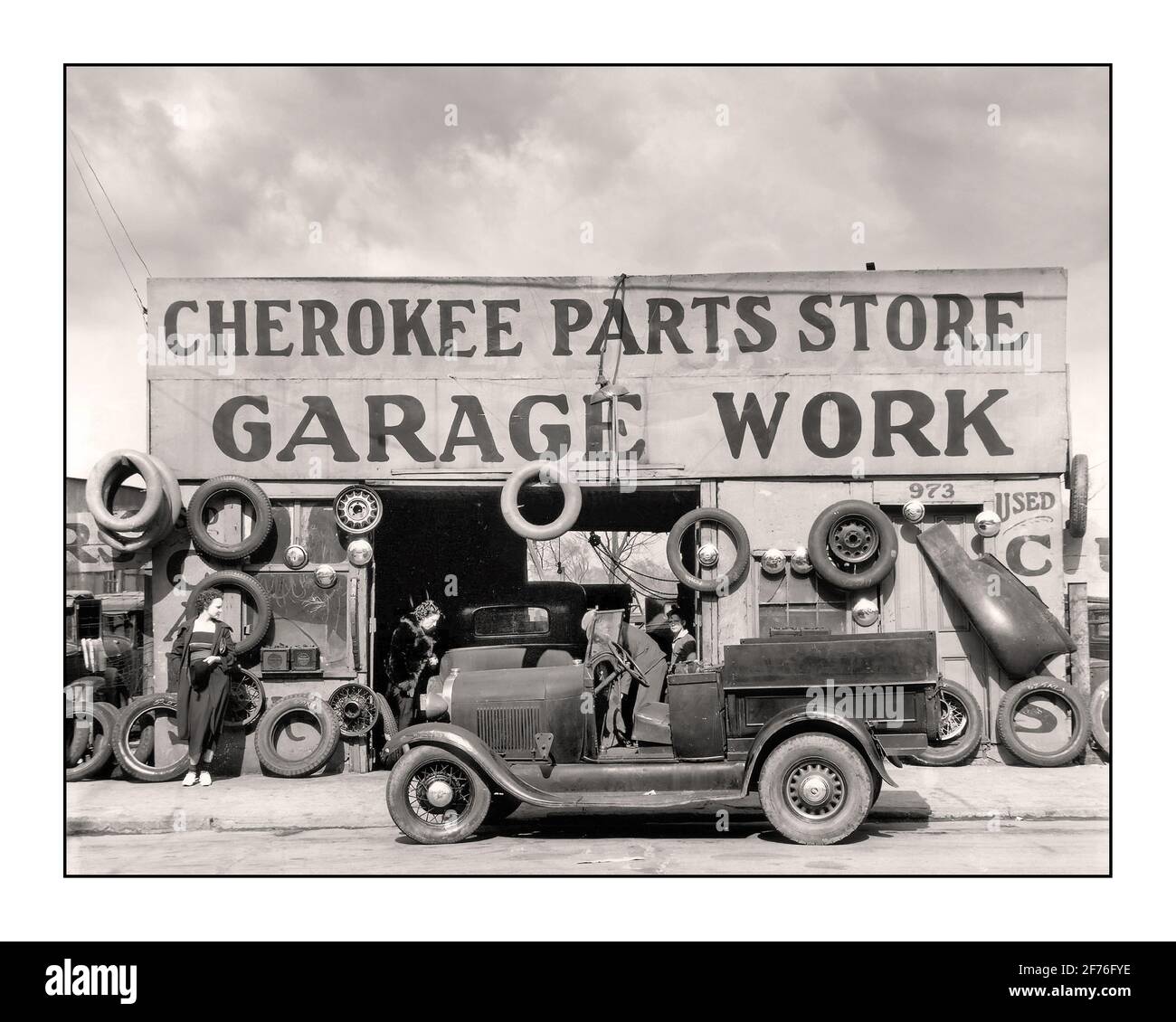 1920 's Auto-Motorwagen Cherokee Parts Store Garage arbeiten Reparatur-Service Anlage mit Ford Model EIN offener Pickup-Truck im Vordergrund USA 1900 Lifestyle Mode nach dem 1. Weltkrieg Arbeit Beschäftigung Stockfoto