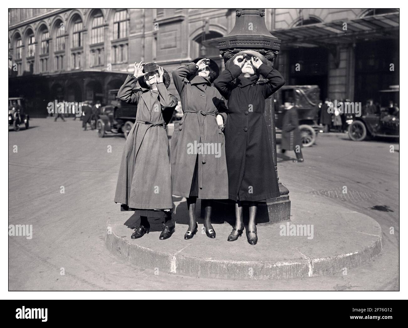 SONNENFINSTERNIS JAHRGANG der 20er Jahre drei Pariser Frauen beobachten die Sonnenfinsternis vom 8. April 1921 auf dem Cour du Havre, neben dem gare Saint-Lazare. Cour du Havre, gare Saint-Lazare, Paris, Frankreich. Datum: 8. April 1921 Stockfoto