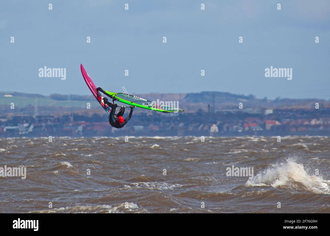 Portobello, Edinburgh, Schottland, UK Wetter. April 2021. Windsurfer genießen die herausfordernden Bedingungen der NW-Winde 31 km/h mit potenziellen Böen von 49 km/h Temperatur von 6 Grad. Im Bild: Erfahrener Windsurfer, der etwas Luft auf dem Firth of Forth nimmt. Stockfoto