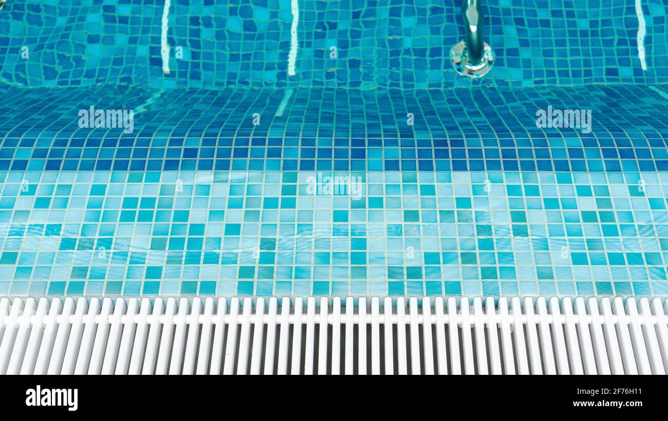 Blick von oben auf den leeren Whirlpool im Swimmingpool mit blauen Mosaikfliesen und Abflussstangen. Transparente ruhige Pool Wasser Hintergrund für Foto-Collage. Glatte ENT Stockfoto
