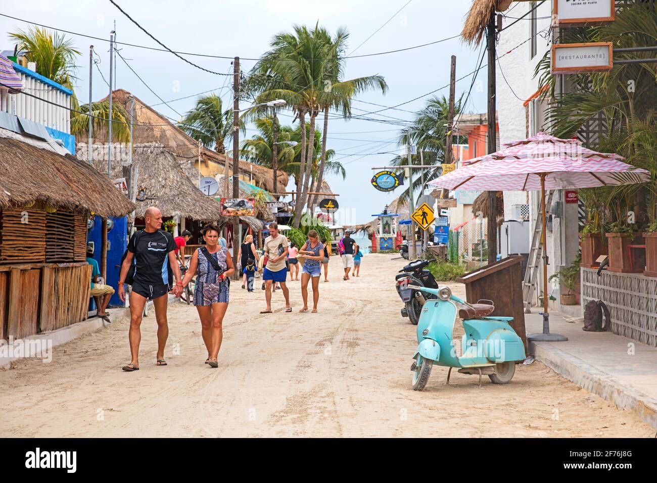 Westliche Touristen, die auf der Isla Holbox, Insel im mexikanischen Bundesstaat Quintana Roo, entlang der Nordküste der Halbinsel Yucatán, Mexiko, auf der Straße spazieren Stockfoto