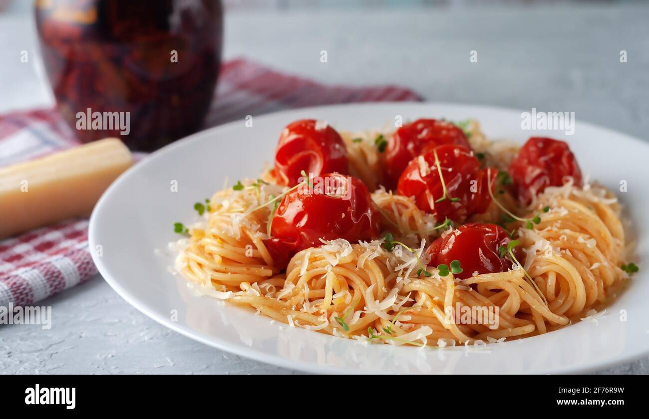 Pasta mit gebackenen Tomaten, Parmesan und Micro-Greens Stockfoto