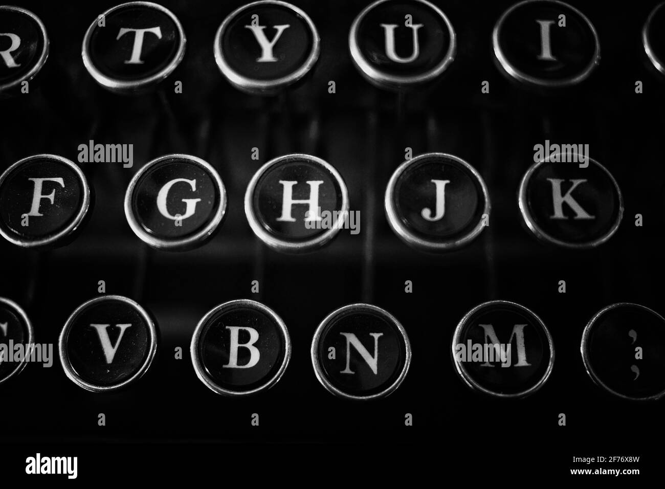 Nahaufnahme der antiken Schreibmaschinentasten mit deutlich abgebildeten Buchstaben. In Schwarz-Weiß fotografiert. Stockfoto