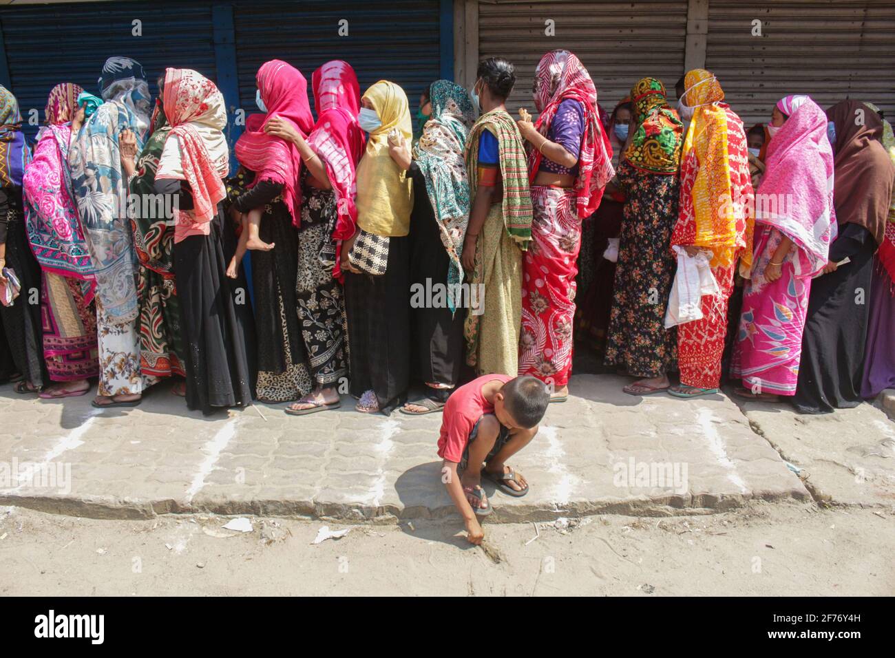 Frauen versammeln sich in einer Schlange, um Reis und Mehl vom Open Market Sale (OMS) in Modu Shohid, Sylhet, zu kaufen. Eine landesweite Sperrung wurde für 7 Tage verhängt. Bangladesch. Stockfoto