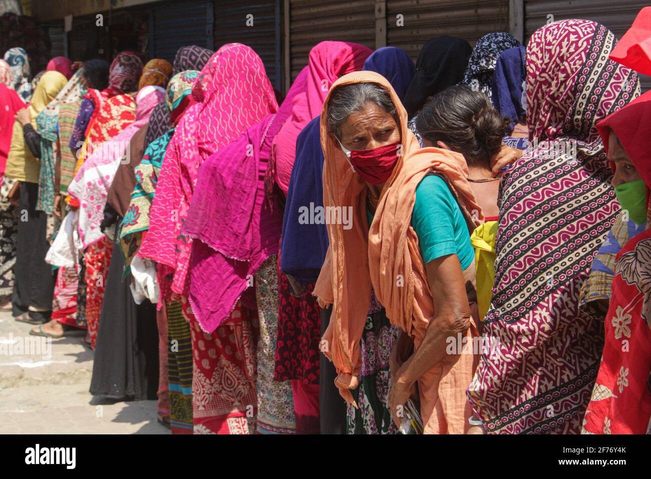 Frauen versammeln sich in einer Schlange, um Reis und Mehl vom Open Market Sale (OMS) in Modu Shohid, Sylhet, zu kaufen. Eine landesweite Sperrung wurde für 7 Tage verhängt. Bangladesch. Stockfoto