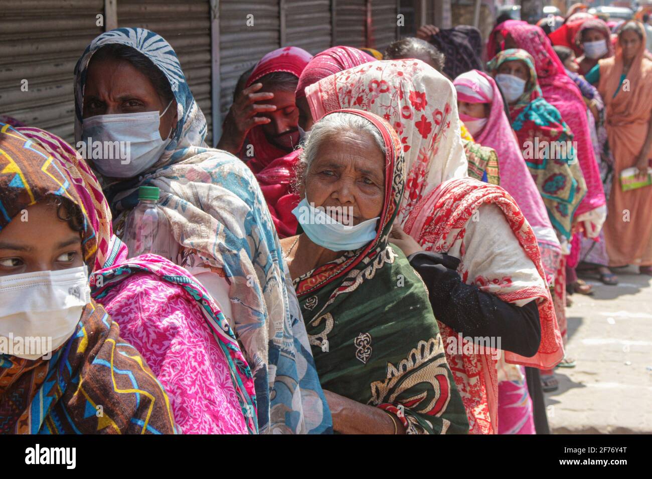 Frauen versammeln sich in einer Schlange, um Reis und Mehl vom Open Market Sale (OMS) in Modu Shohid, Sylhet, zu kaufen. Eine landesweite Sperrung wurde für 7 Tage verhängt. Bangladesch. Stockfoto